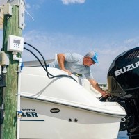 MarineWarehouse/Man-hooking-up-a-Flushmaster-2-Outlet-Automated-Outboard-Flushing-System-to-a-Suzuki-Outboard__99405.1739477314