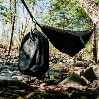 MarineWarehouse/Mission-CASSI-Dual-Compartment-18L-Backpack-hanging-on-a-hammock-in-the-woods__04528.1739477266